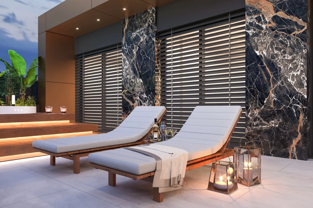 Leżaki na tarasie przed dużymi oknami z żaluzjami fasadowymi Żaluzje fasadowe